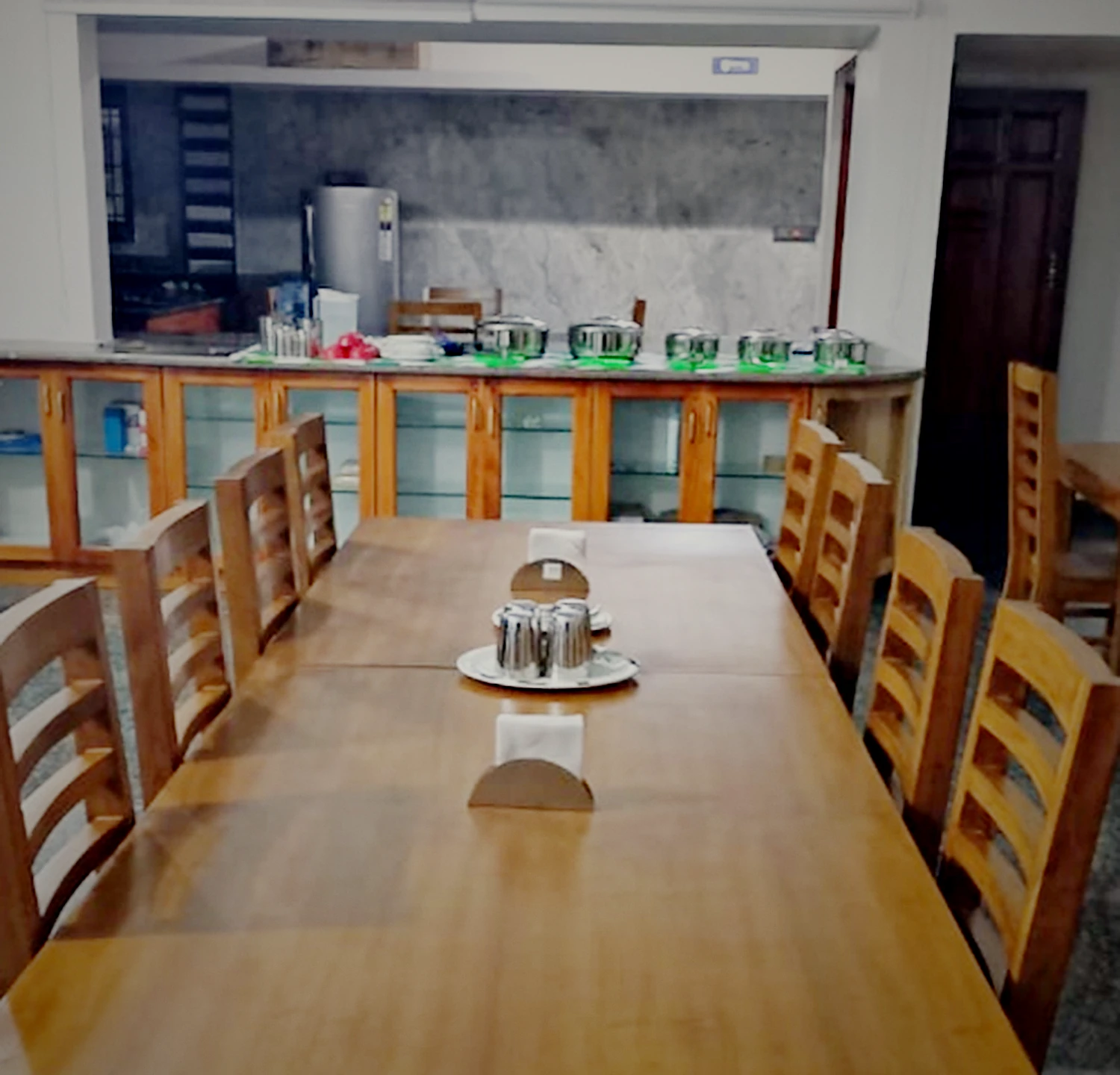 The long wooden dining table in the house, laid and waiting